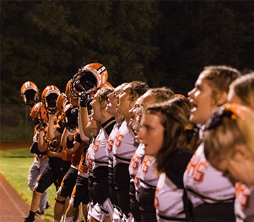 Football players and cheerleaders on the sideline during a game